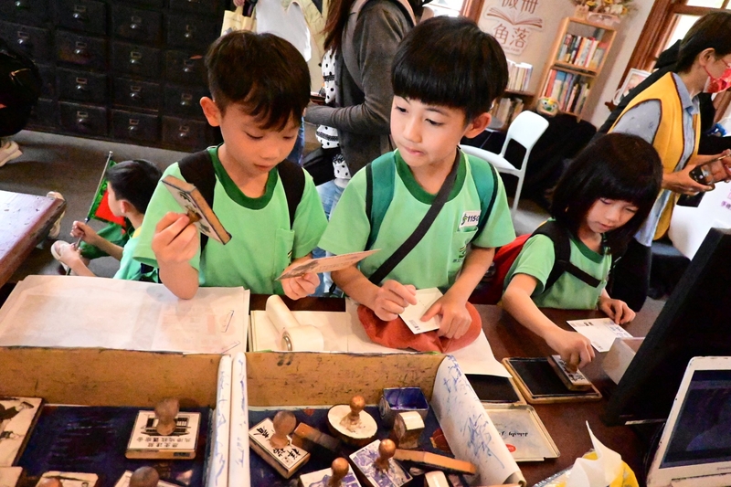 小朋友們低著頭、專注集章的可愛模樣。